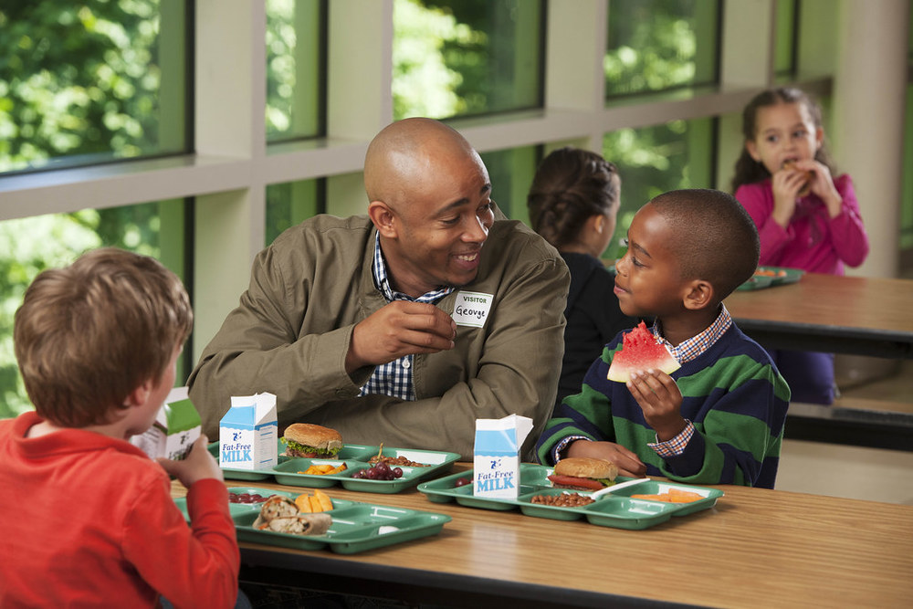 dad eating lunch with son and friend
