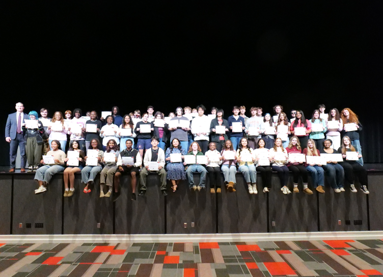 students on stage holding certificates 
