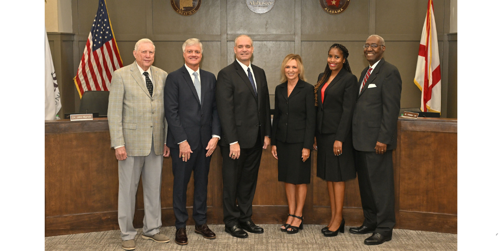 SIX ADULTS IN FRONT OF WOODEN CITY COUNCIL DAIS