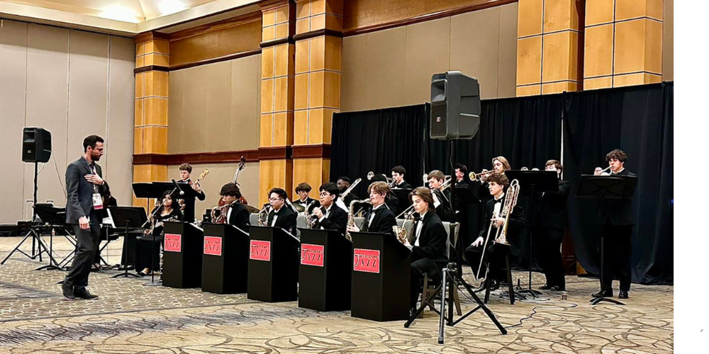 MAN INSTRUCTING STUDENT MUSICIANS IN BALLROOM