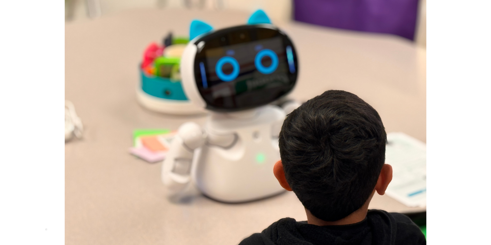 ROBOT ON TABLE FACING YOUNG MALE STUDENT
