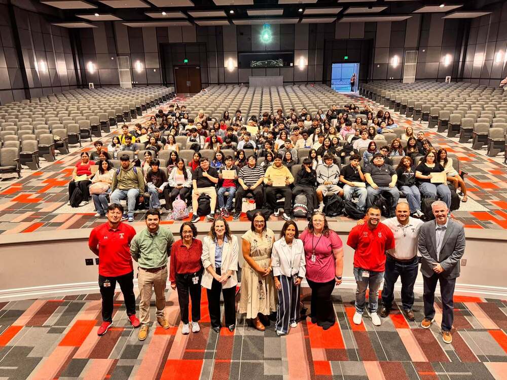 students and adults in large auditorium