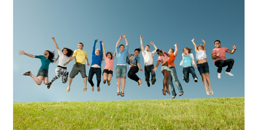 STUDENTS ON GRASSY FIELD JUMPING JUBILANTLY IN AIR