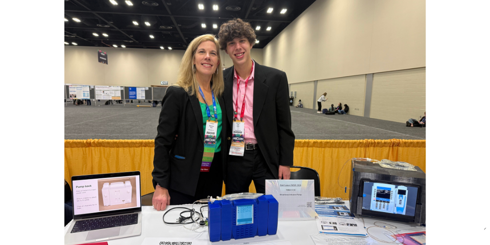 TWO PEOPLE STANDING AT EXHIBIT TABLE