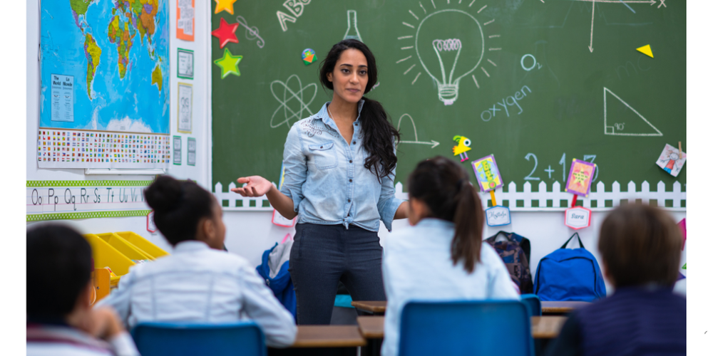 FEMALE TEACHER WITH SCIENCE-ESQUE CLASSROOM