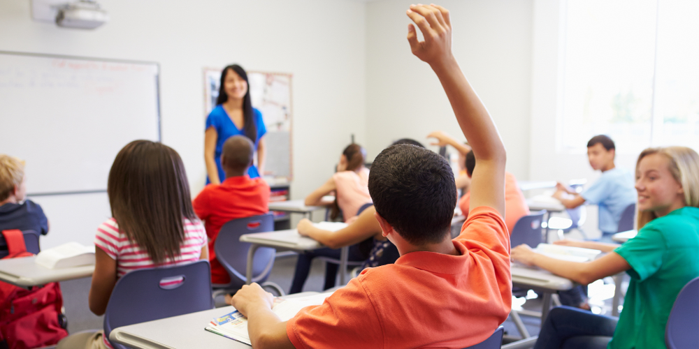 TEACHER TEACHING STUDENT RAISING HAND
