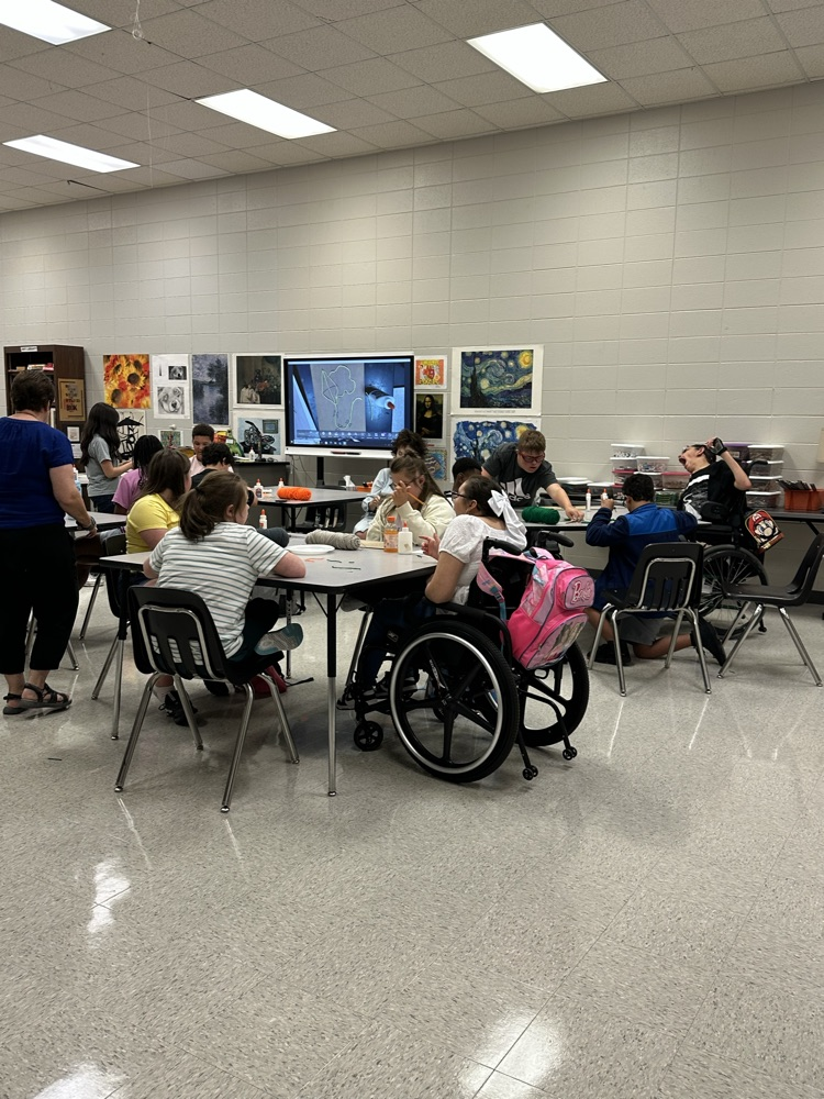 students sitting at art table 