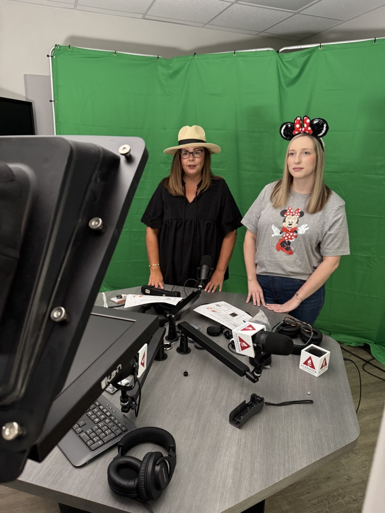 two women in front of tv green screen