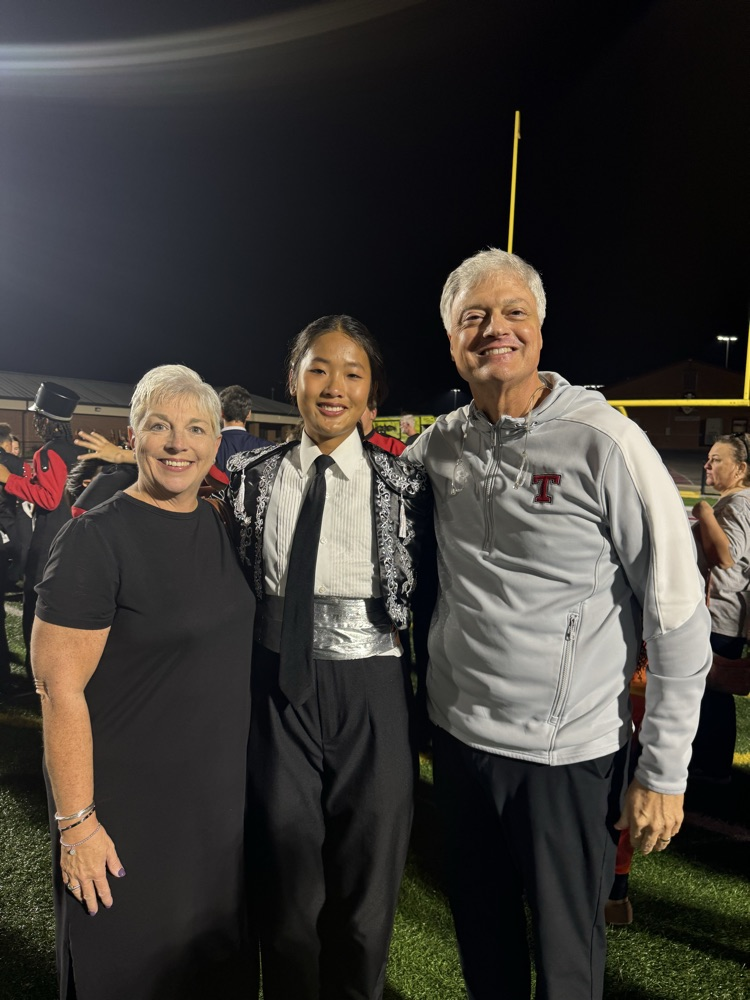 three people on field smiling