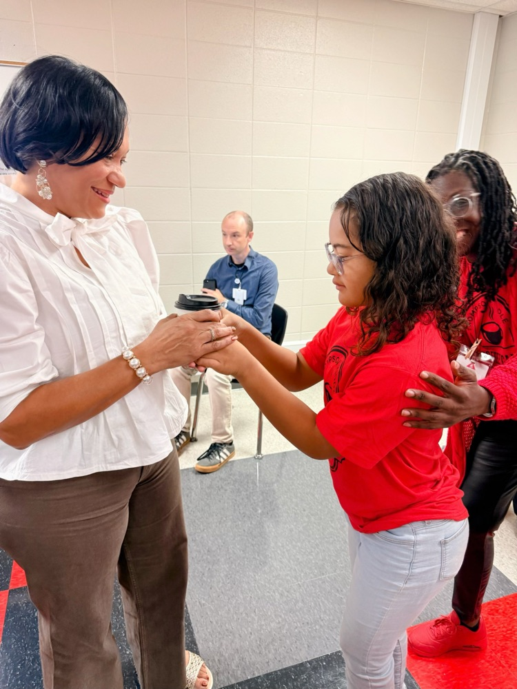 Teacher receiving coffee from a student as part of a project