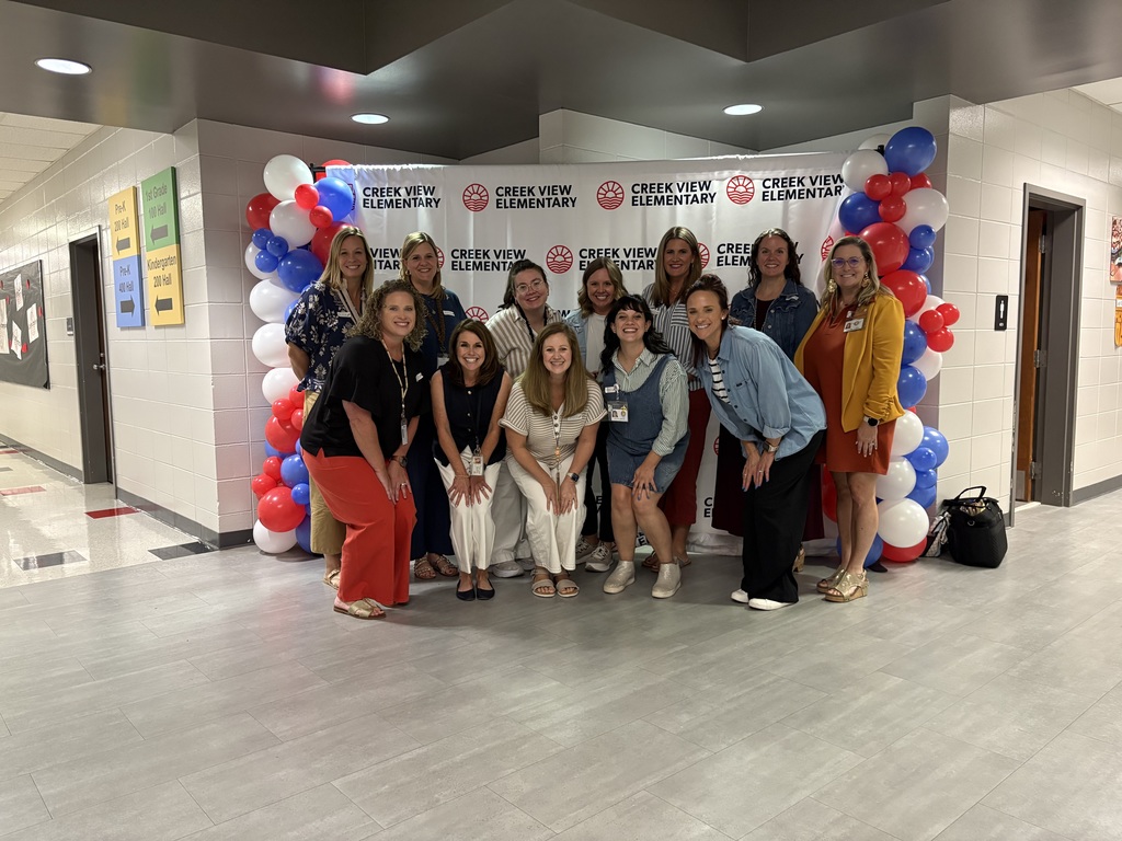group of educators in front of step repeat