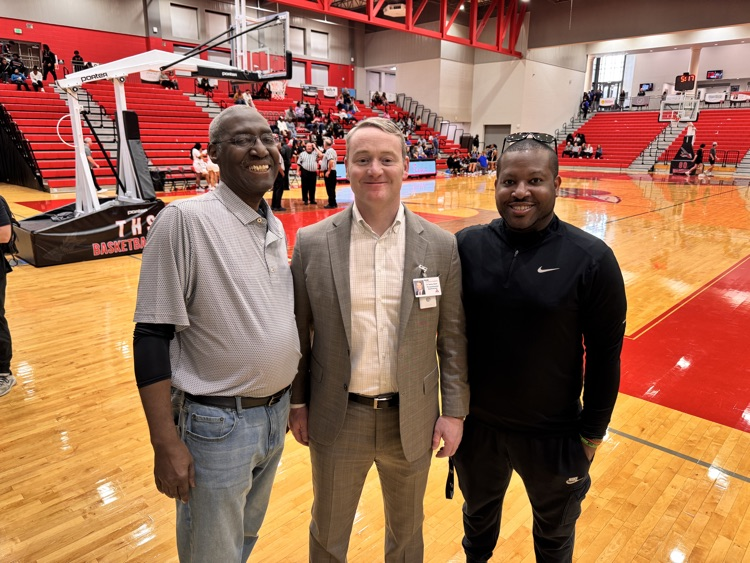 Three men posing for a photo on the basketball court