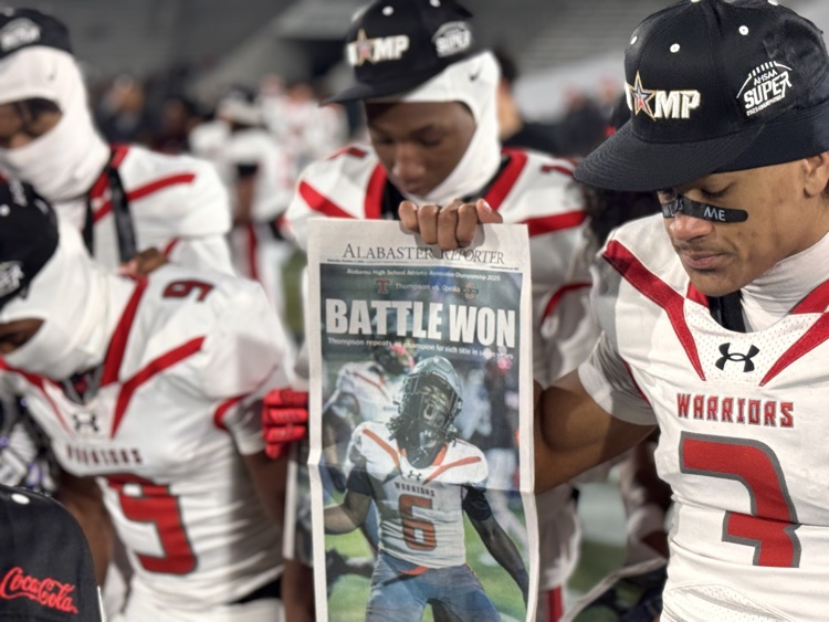 Player holding up newspaper headline reading, “Battle Won"