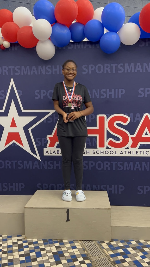 female swimmer, standing on stage with plaque and metals