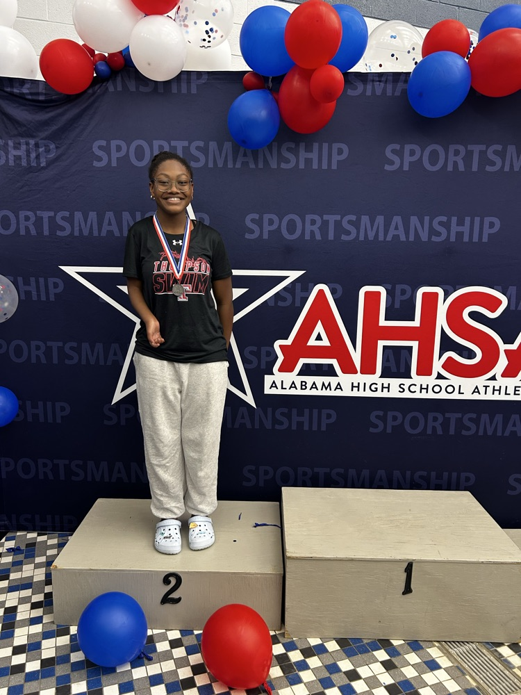 female swimmer standing on stage receiving metals posing for