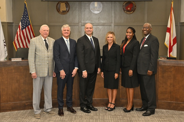 six people standing in board chambers 