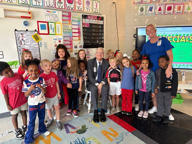 Man posing with a group of students in a classroom