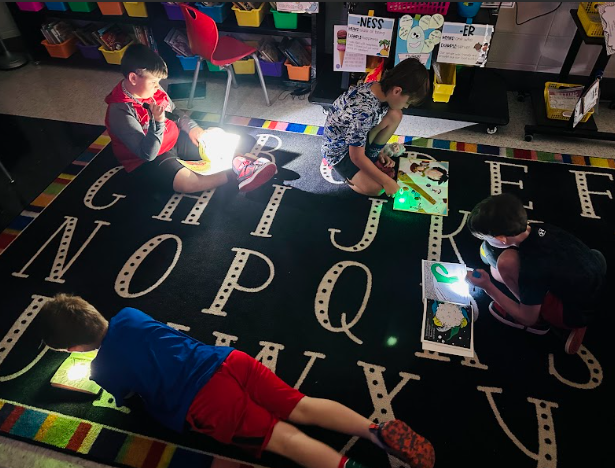boys reading with flashlights
