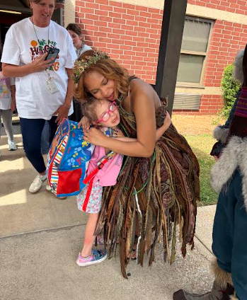 little girl hugging a girl dressed as a troll