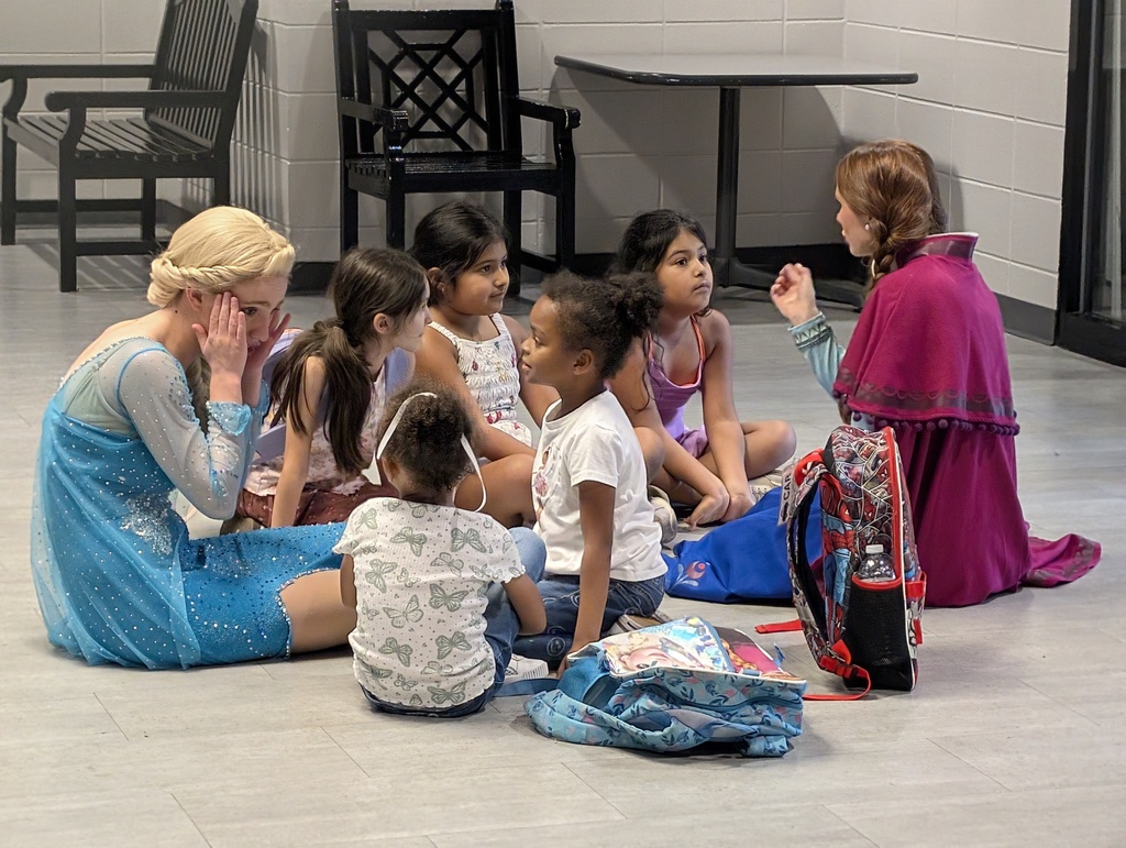 little girls sitting with anna & elsa