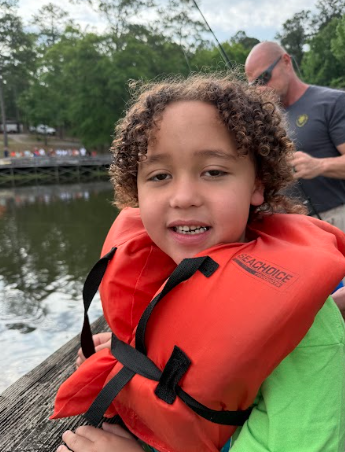little boy smiling wearing a life jacket