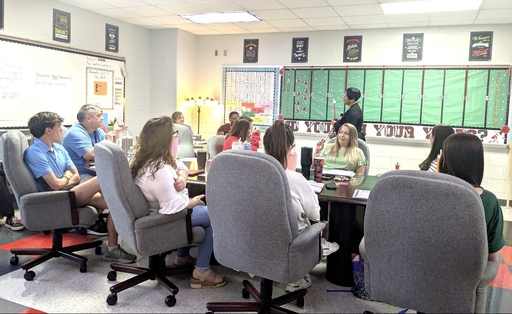 A woman instructing other educators