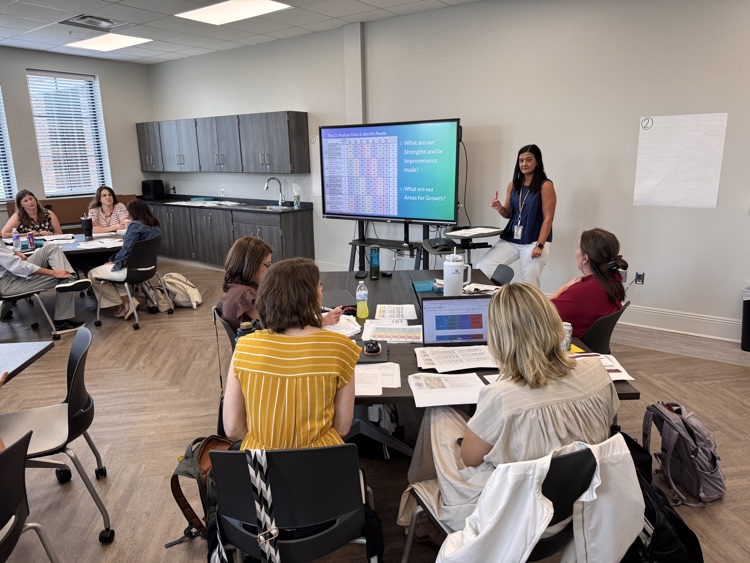 A woman at a podium, instructing educators on math