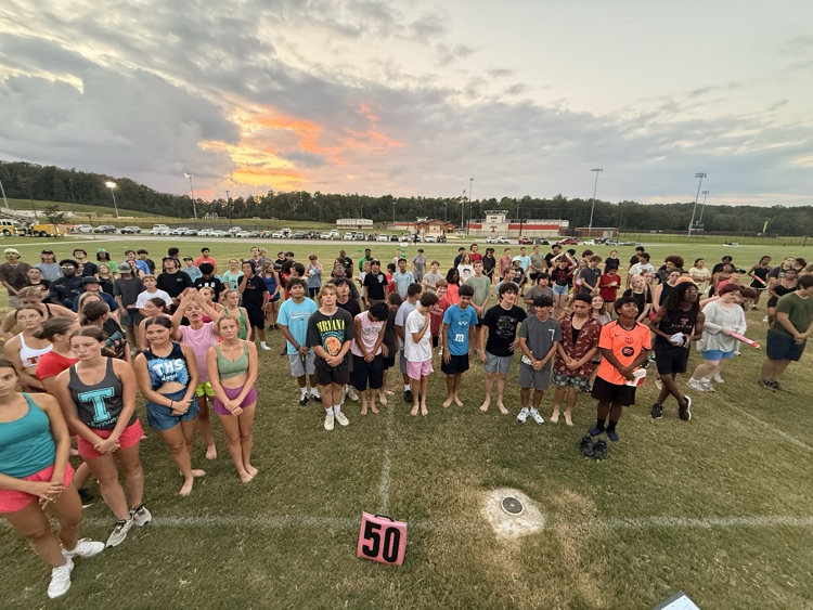 band students on field at sunset all wet after hose down from fire truck as part of fun event