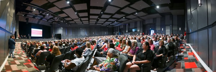 wide angle photo of auditorium filled by people
