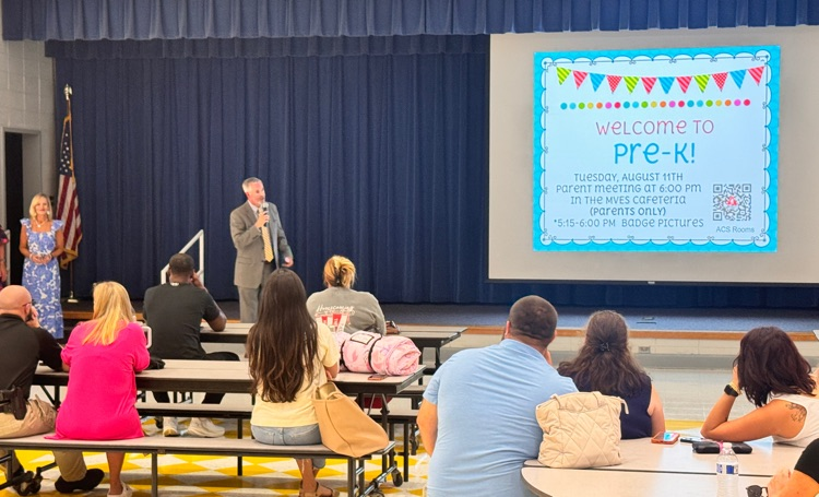 Mann addressing a full audience