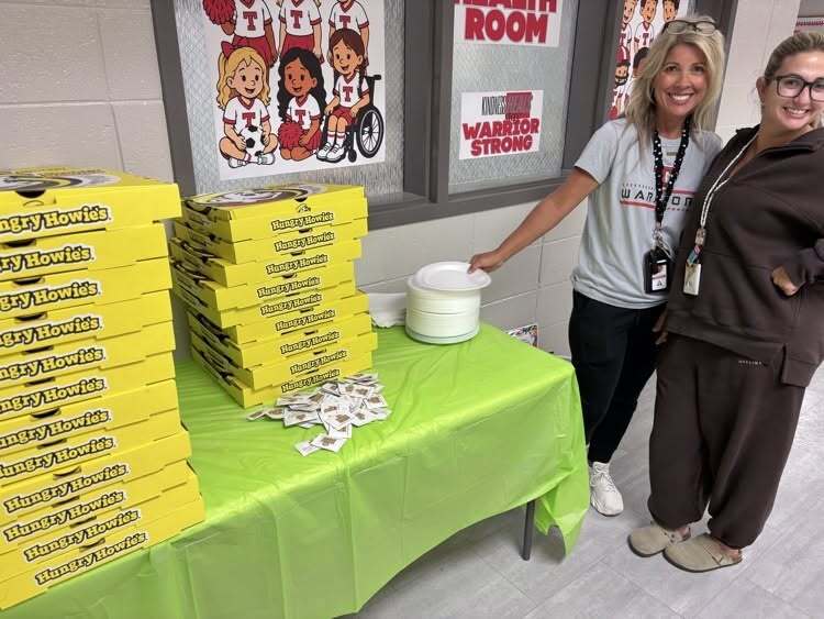 two teachers with pizza