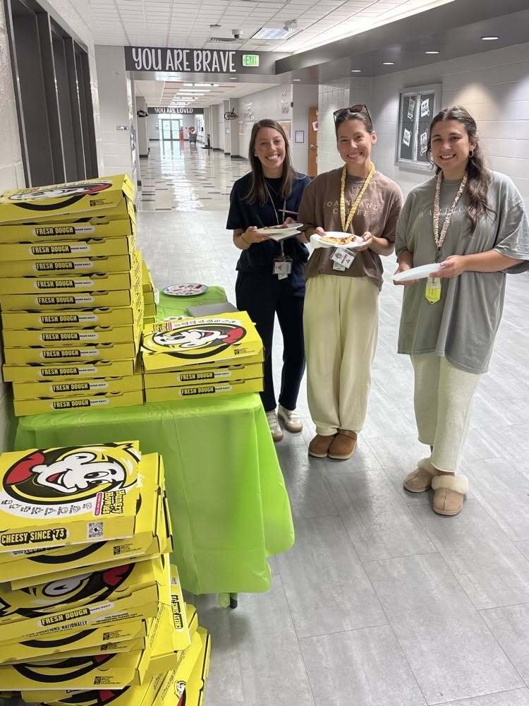 three teachers with big boxes of pizza