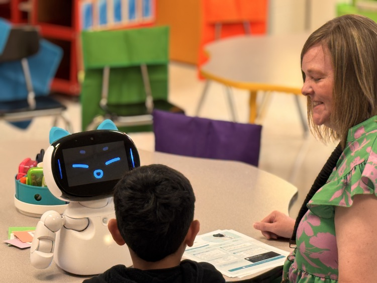 Teacher working with student with robot