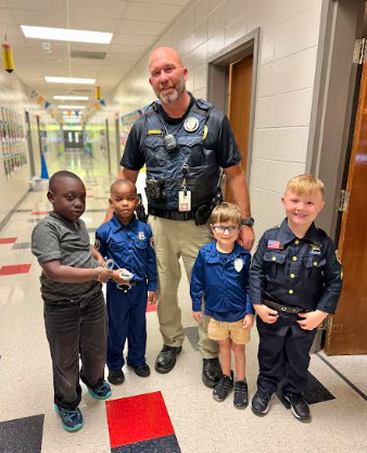 4 boys standing with SRO dressed as policeman