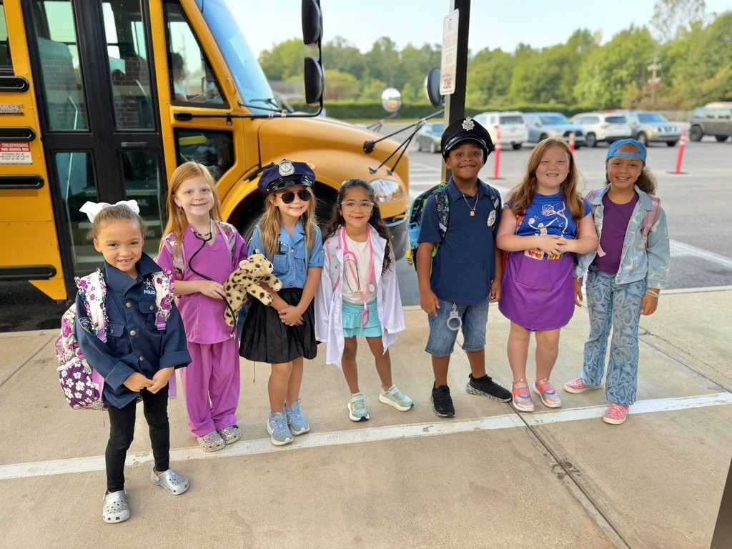 kids standing in front of bus dressed up