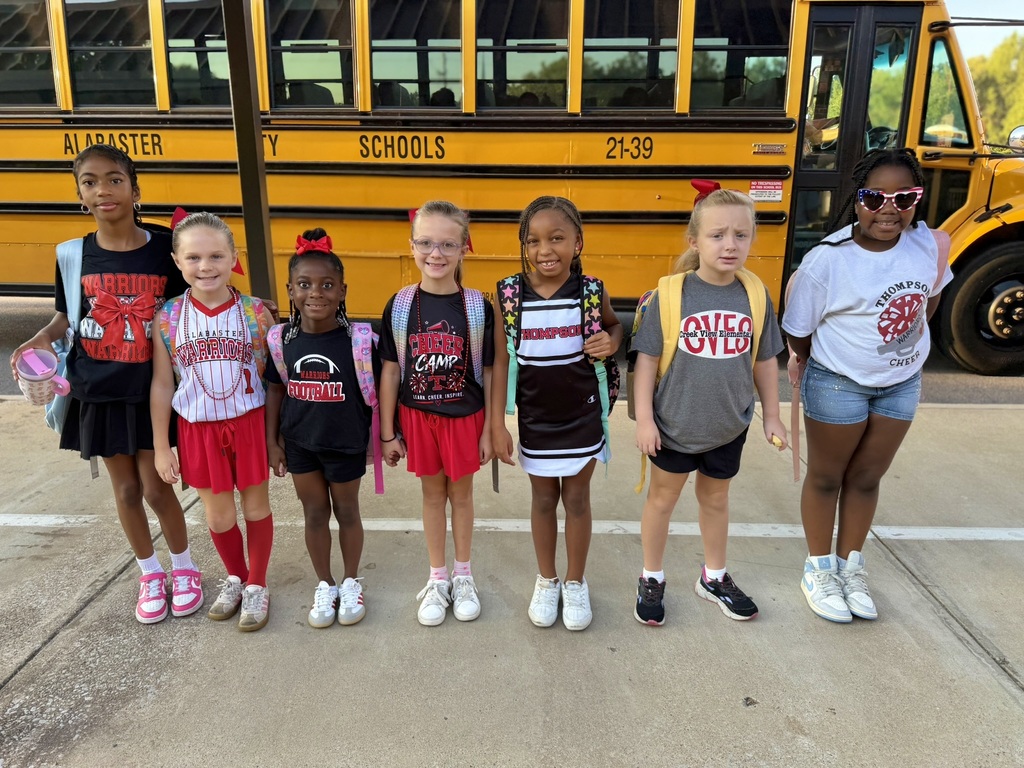 girls standing in front of bus