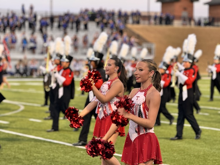 Cheerleaders and band on a football field