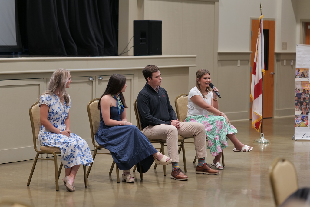 A student holding a mic on a panel centered on education