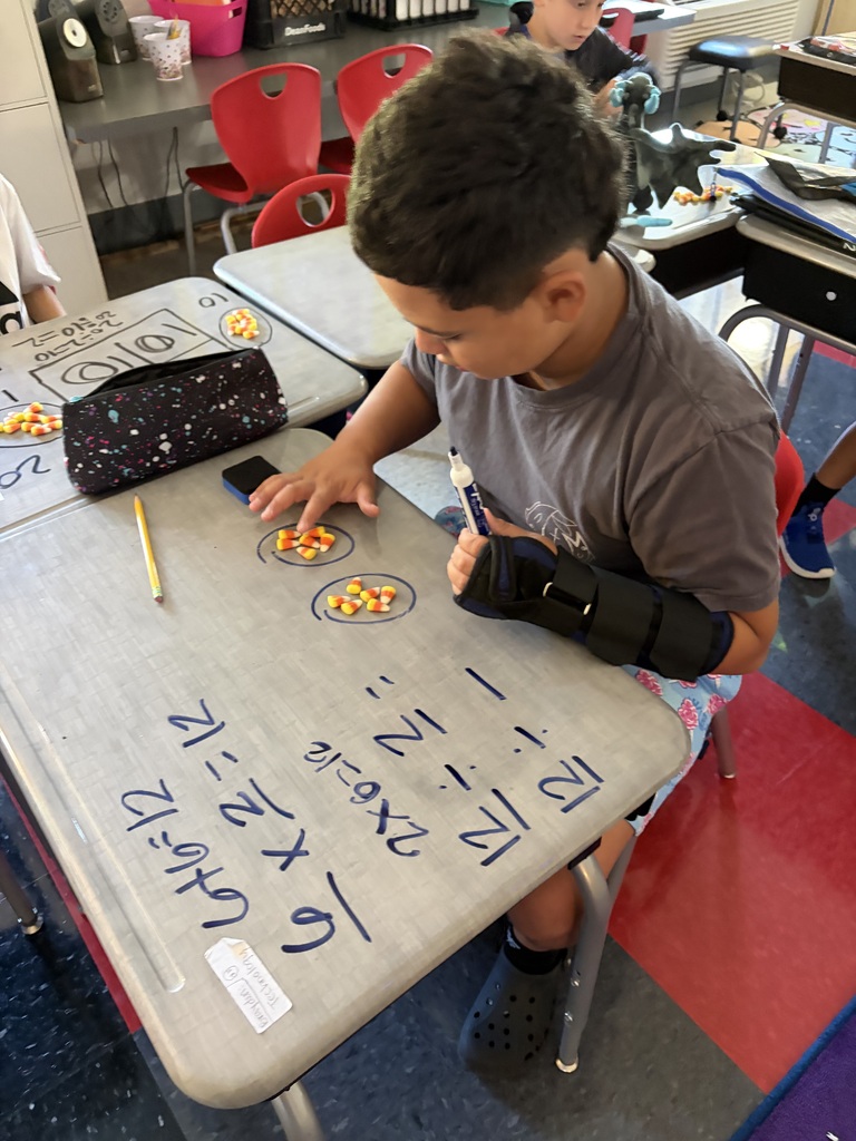 boy doing math on desk with candy corn