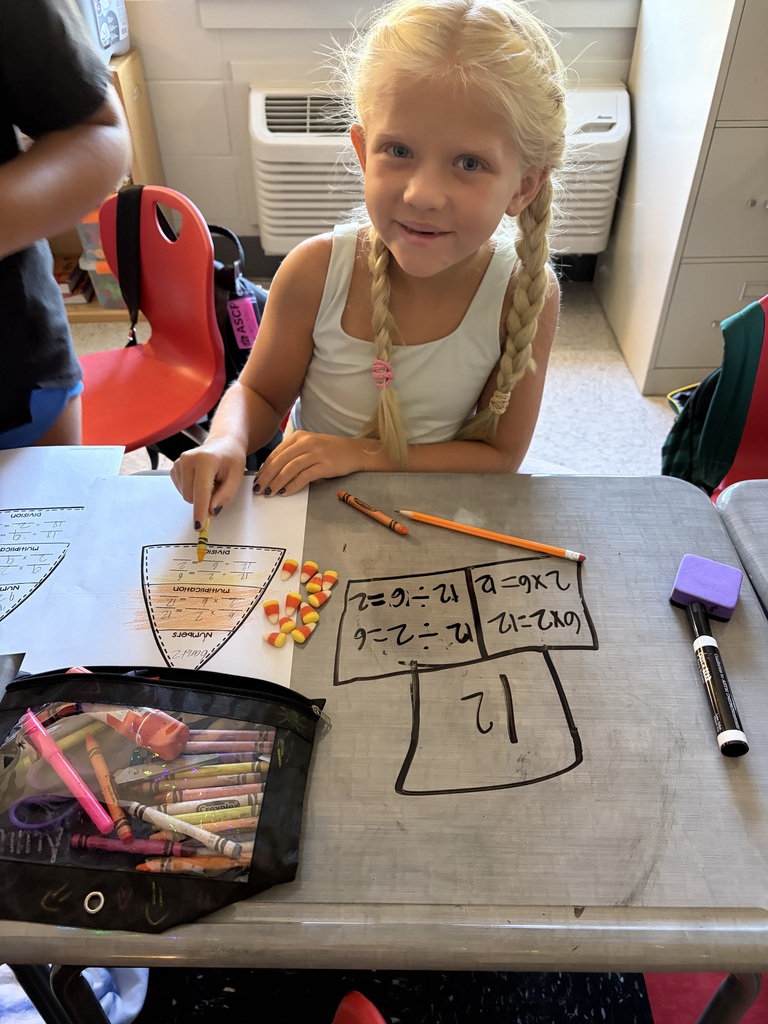 girl doing math on desk with candy corn