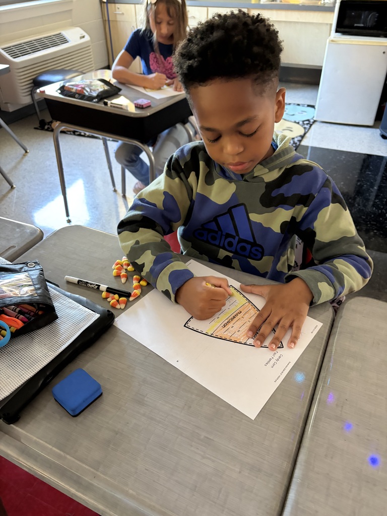boy doing math on desk with candy corn