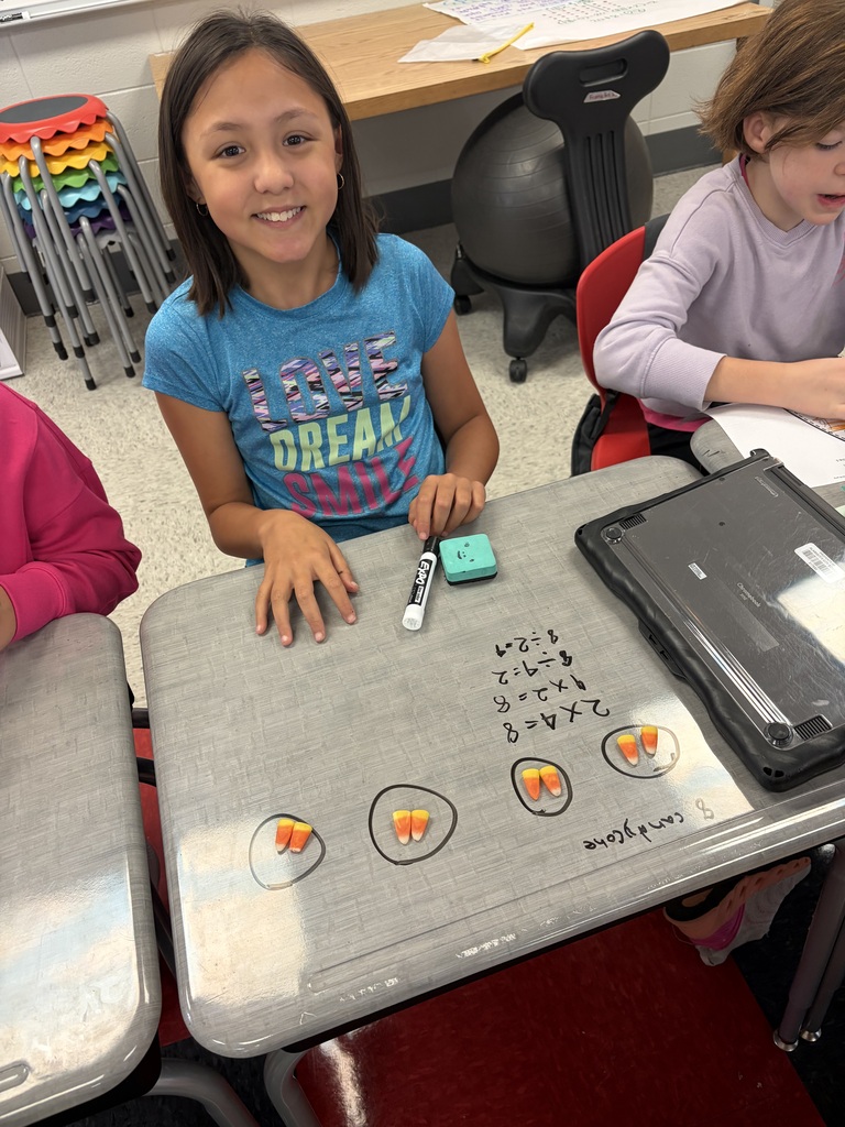 girl doing math on desk with candy corn