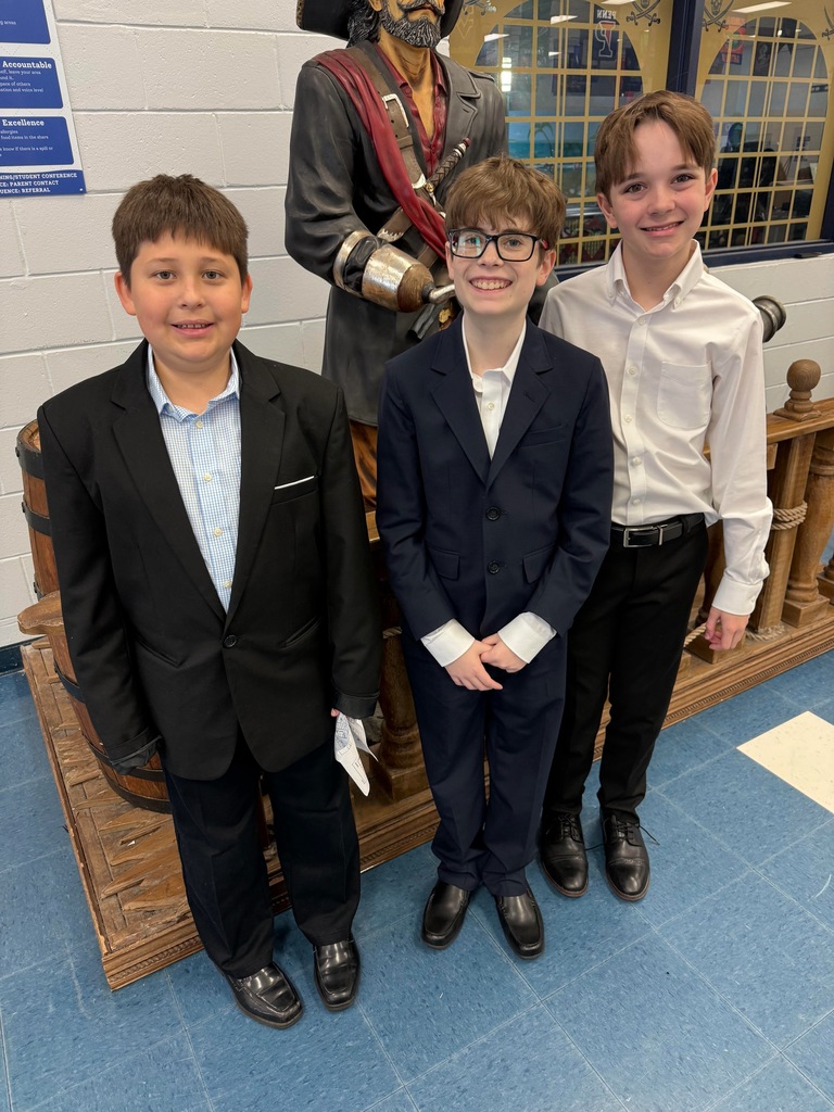 3 boys in front of a pirate statue 