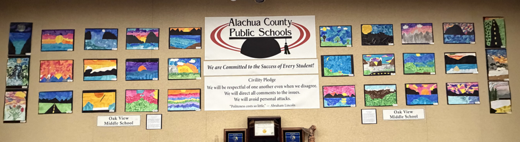 Student Art displayed in the boardroom. Student art is in a collage style and focuses mostly on landscapes. 