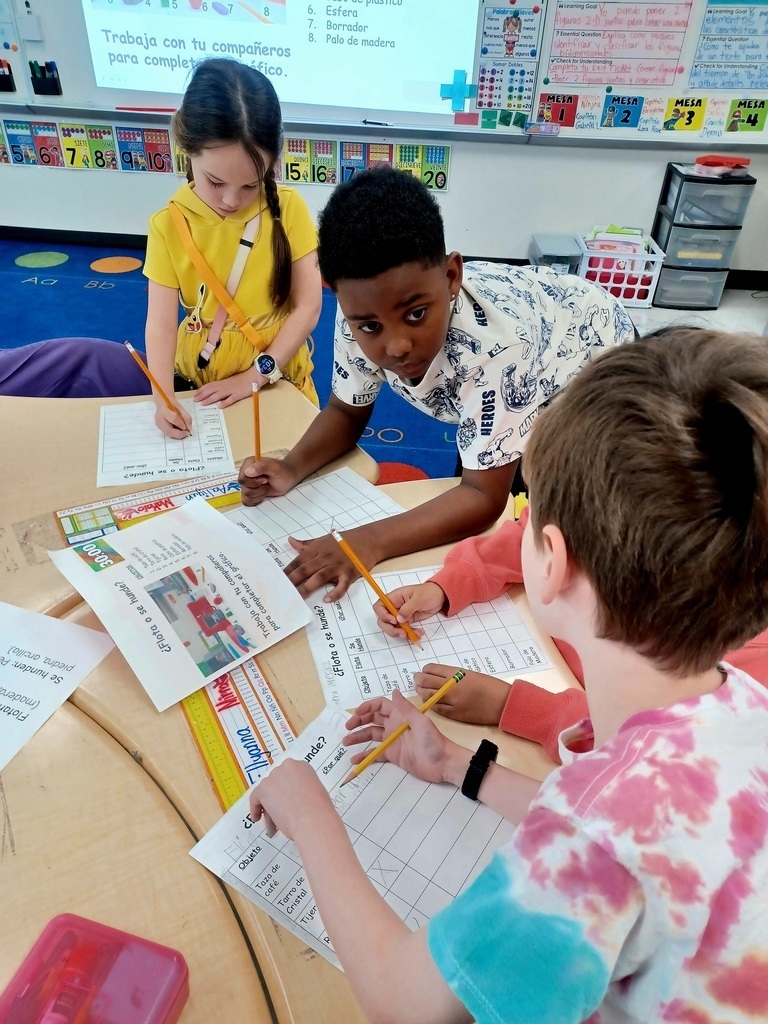 three students working at a desk