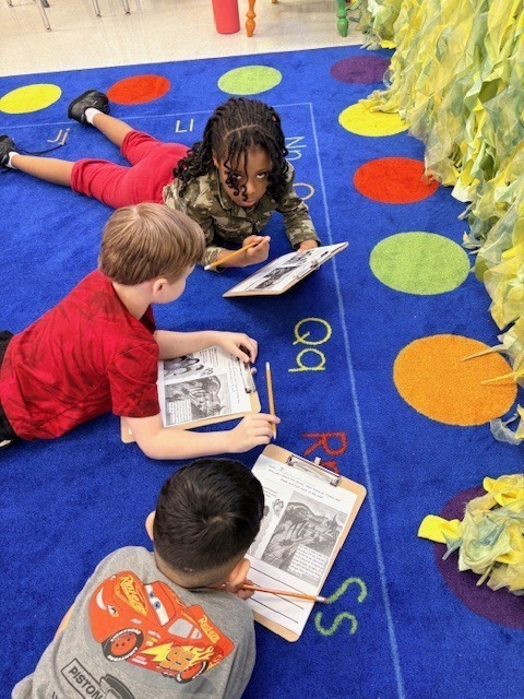 three students working on the carpet