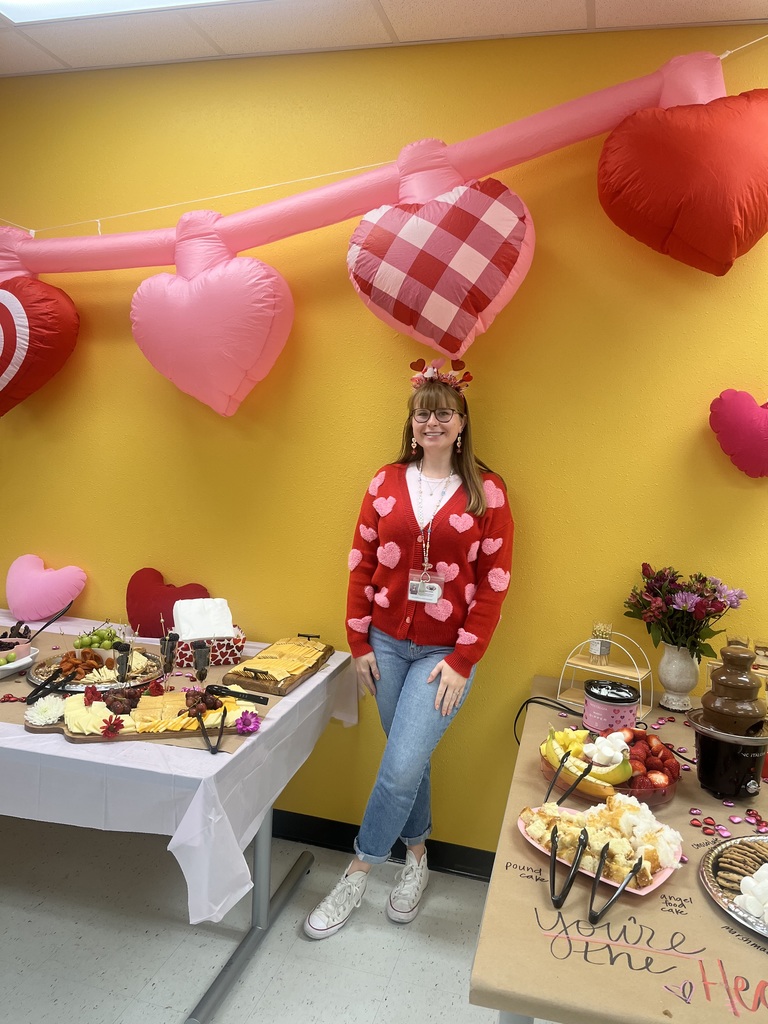 teacher in front of heart ballons