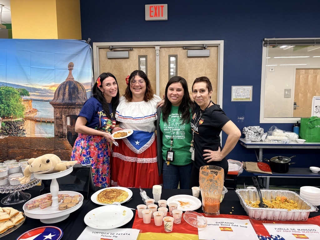 group of 4 teachers in front of a food table