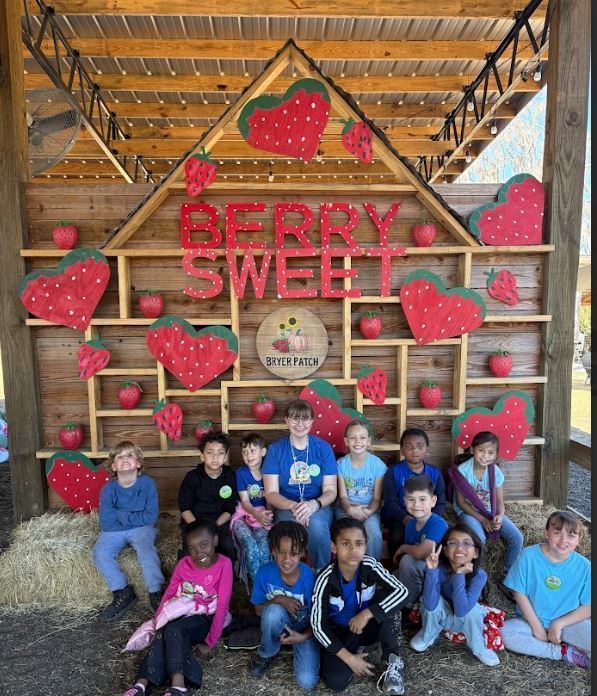 group of students in front of wooden strawberries
