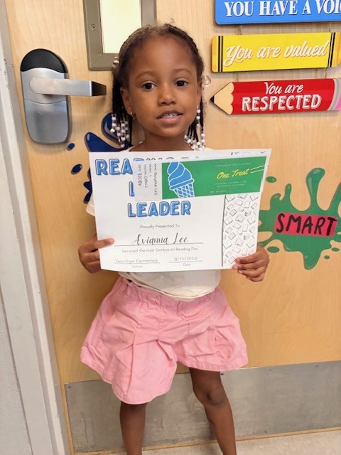 student in front of a door with a certificate